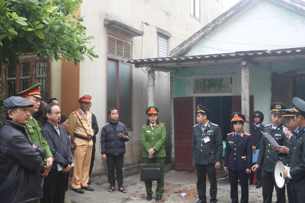 Chấp hành viên công bố Quyết định cưỡng chế thi hành án trước sự chứng kiến của các lực lượng chức năng.