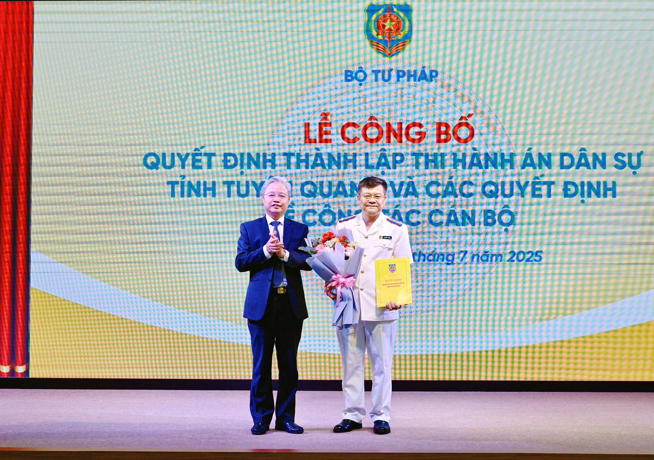 Ông Nguyễn Quang Thái - Phó Bí thư chuyên trách Đảng uỷ Bộ Tư pháp trao Quyết định của Bộ trưởng Bộ Tư pháp cho ông Nguyễn Tuyên - Trưởng THADS tỉnh Tuyên Quang (Ảnh: Lê Hanh)