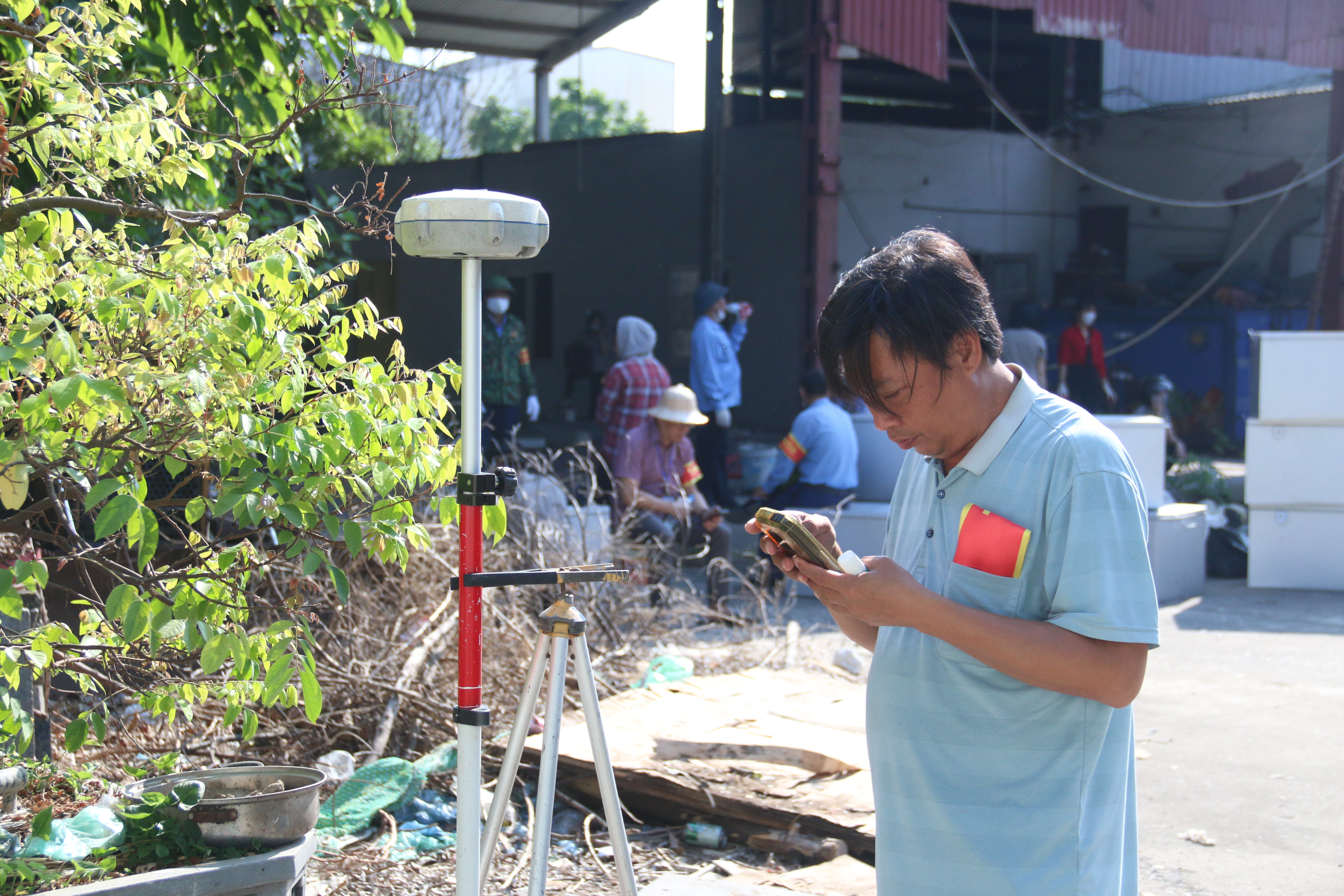 Kỹ thuật viên đo đạc xác định mốc giới các thửa đất chuyển giao quyền sử dụng cho người mua được tài sản bán đấu giá