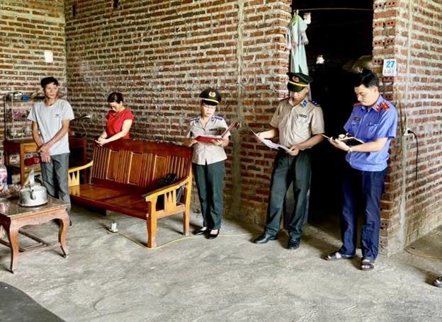 Chấp hành viên Lương Hồ Điệp cùng các đồng nghiệp Phòng Thi hành án dân sự Khu vực 2 và lực lượng chức năng tỉnh Tuyên Quang kê biên tài sản đối với hộ gia đình ông Hà Văn Tế. (Ảnh: Lê Hanh)